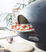 polito giotto wood fired pizza oven in black with benchstand with pizza peel