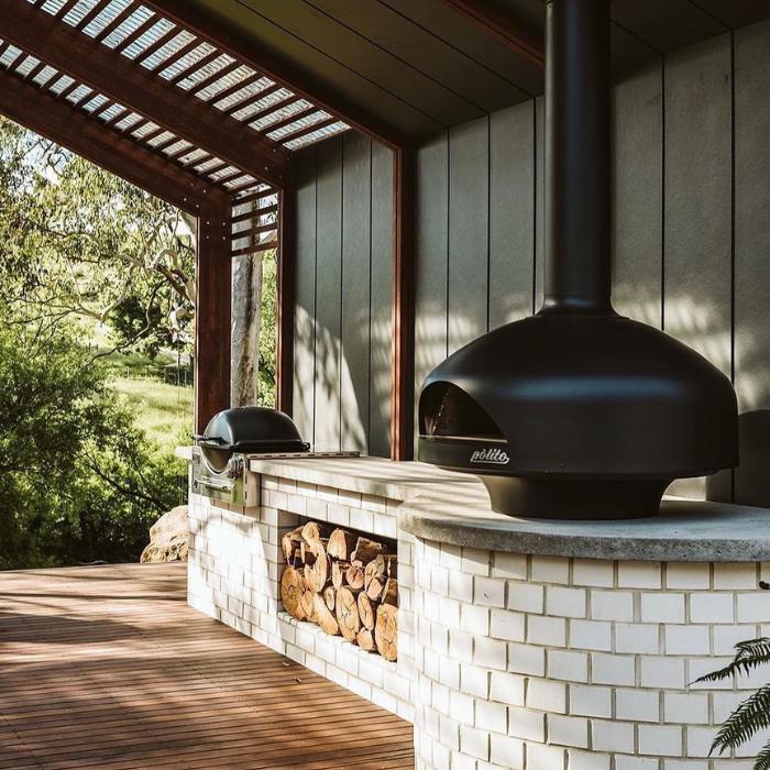 polito giotto wood fired pizza oven in black with benchstand outdoor kitchen with log storage